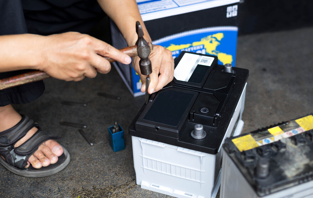 Batteries for Electric Scooters and Motorcycles The fuel tank, control center, and the performance limiter in any e-scooter happen to be the battery for electric scooter, bringing the popularity of lithium-ion chemistries. They have much greater gravimetric and volumetric energy density than lead-acid. Light electric vehicles have a standard lithium-ion pack with 150-200 Wh/kg, and lead-acid batteries with 30-50 Wh/kg. Thus, you can pack more watt-hours into a smaller, slimmer pack, keep weight low, and free designers to optimize balance, agility, and frame geometry. Their low mass cuts rolling and acceleration losses, and helps real-world range. Inherently lower internal resistance supports higher discharge rates and fast-charge capability alongside controlled heat generation. Hence, riders may exert powerful motors yet still recover useful range in short charging windows. At the cell level, managed charge cut-offs, C-rates, and thermal envelopes let quality packs survive thousands of cycles with limited capacity fade. That stabilizes the daily range and total cost of ownership. All of this fits with e-mobility goals because a durable and efficient battery for electric scooter lowers material throughput and lifetime emissions per kilometer and makes electric two-wheelers handy as everyday and sustainable transport (not just short-hop gadgets). What Is the Average Battery Lifespan? How Long a Lithium-Ion Scooter Battery Usually Lasts For most riders, a lithium-ion battery for electric scooter will give 5-8 years of useful life. That is equal to 1,500-2,000 full charge cycles, according to pack quality and chemistry. Frequent deep discharges, constant full 100% charges, very high C-rate acceleration, and parking the scooter fully charged in the hot sun all speed up aging. They stress the cell's cathode lattice and grow the solid electrolyte interphase on the anode, which slowly steals active lithium. Cooler storage, partial charges (you may think about 20-80%), and letting the BMS manage cut-off voltages help slow this drift in capacity. As a result, the pack keeps a predictable range for more seasons. How This Compares to Older Battery Types Traditional sealed lead-acid and gel batteries in light vehicles might only manage a few hundred cycles, say up to 200, and 1-2 years of everyday use before their usable range drops sharply. That's because they are more sensitive to deep discharge, heat, and sitting in a low state of charge. Lithium-ion packs outlast them by a factor of two or more in real-world service, along with higher cycle counts, lower self-discharge, and far less maintenance. That implies fewer replacements over the lifetime of the scooter and a lower total cost per kilometer ridden. Mechanic Repairing the Battery with a Hammer
