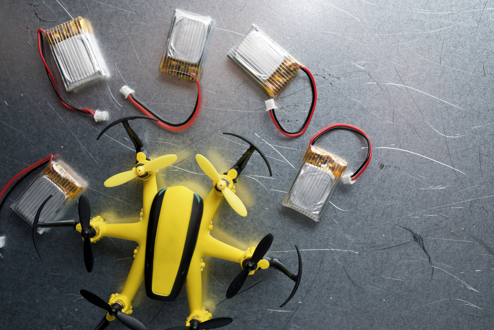 Yellow Drone and Batteries on a Metal Table